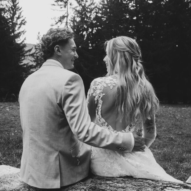 Intimate summer wedding couple sitting outdoors in Garmisch surrounded by nature — planned by AWIKA WEDDINGS.