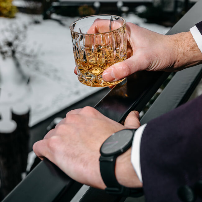 guest holding drink at alpine wedding terrace moment