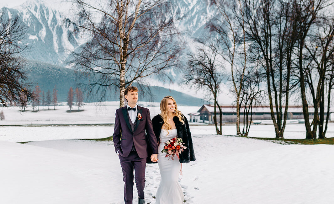 bride and groom walking in snowy alpine landscape