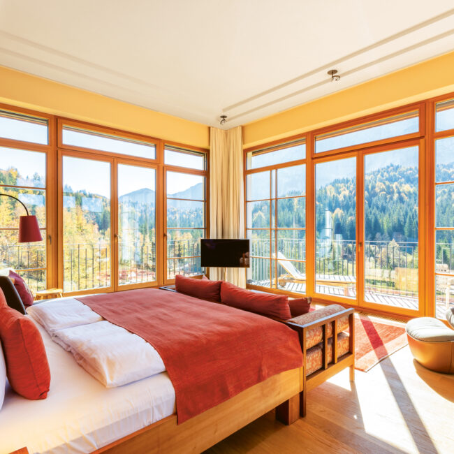 Spacious suite at Schloss Elmau with panoramic alpine views and warm interior design