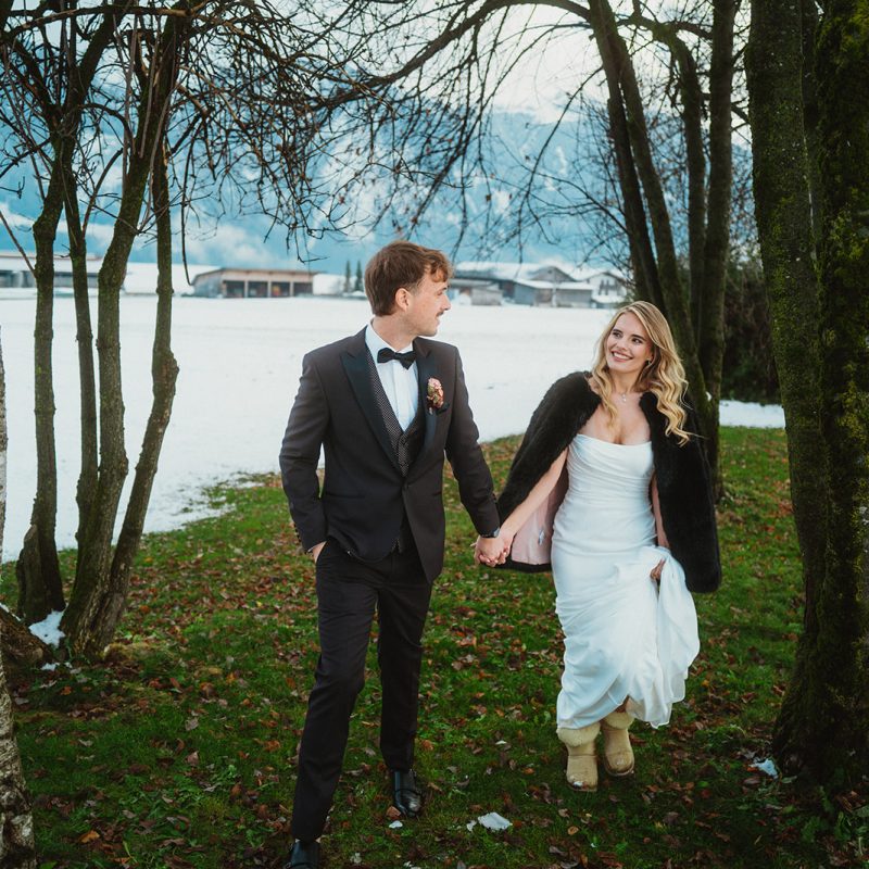 Winter wedding couple walking outdoors in Obermieming, Austria — planned by AWIKA WEDDINGS.